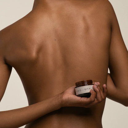 Person holding a jar of Kiko Vitals Sacred Moon Balm on a neutral background