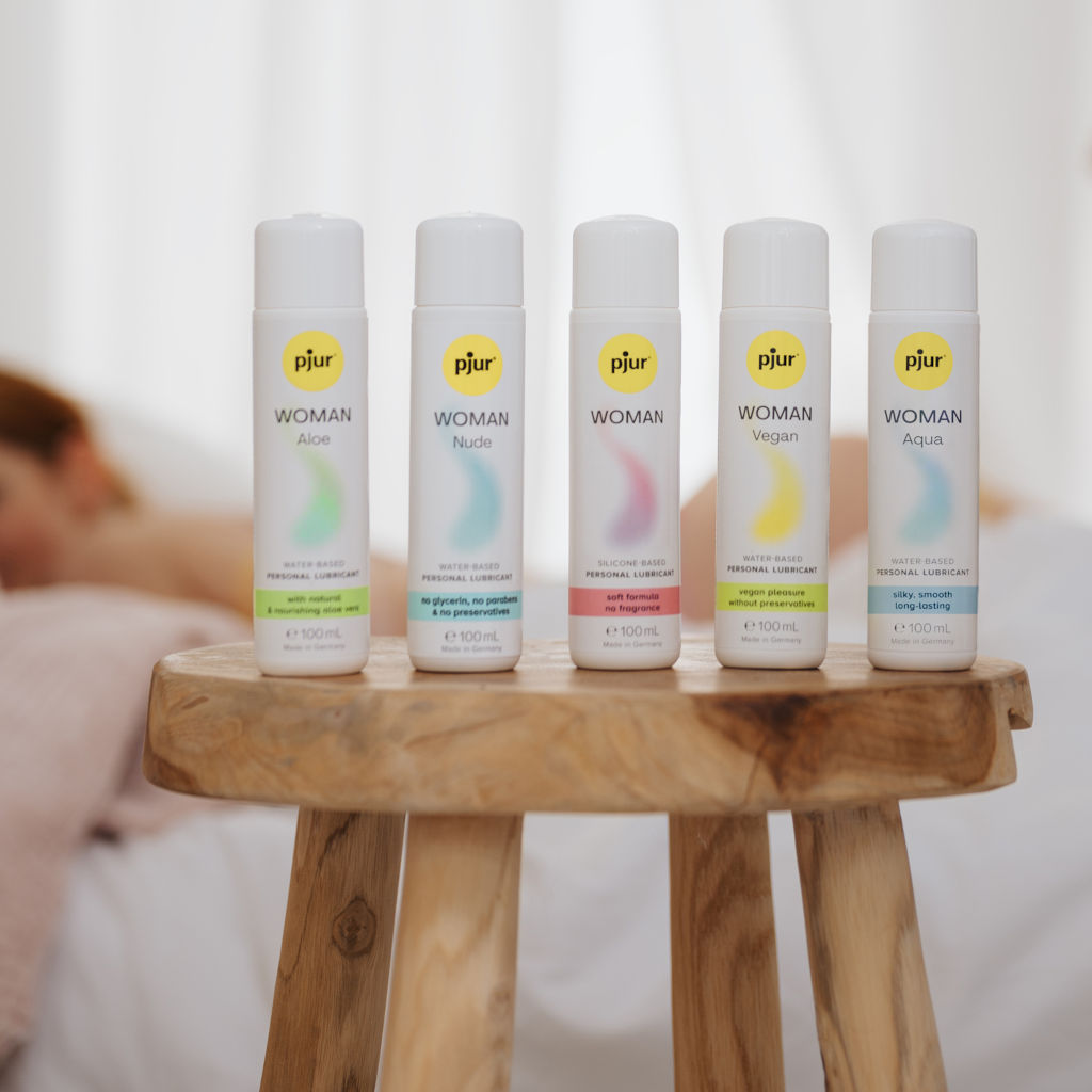 Five PjurWoman products on a wooden stool with a blurred background
