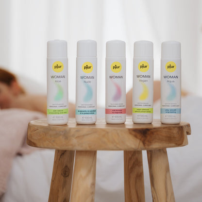 Five PjurWoman products on a wooden stool with a blurred background