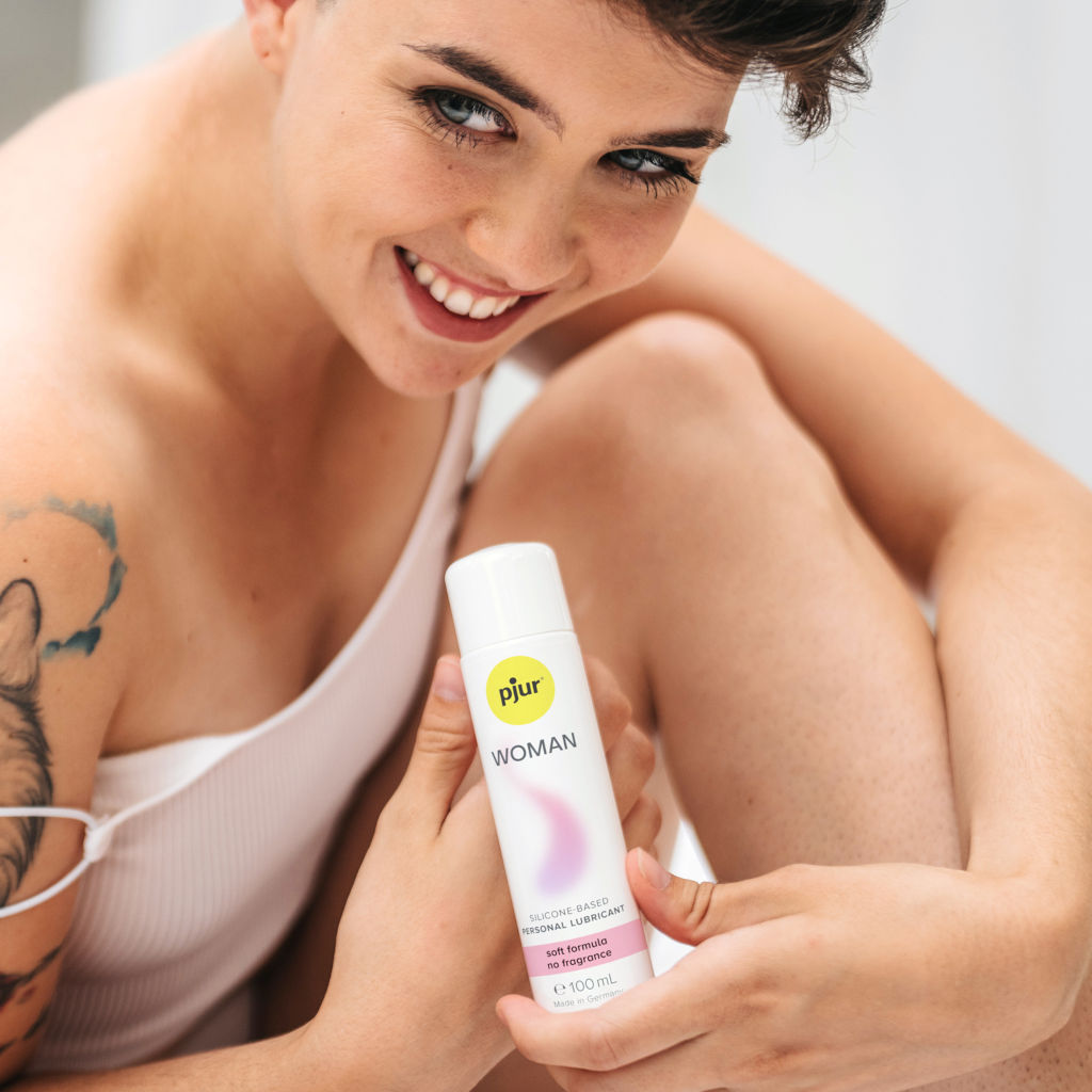 Woman holding a pjur product with a blurred background